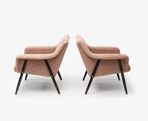Two brown boucle armchairs with black legs on a white background